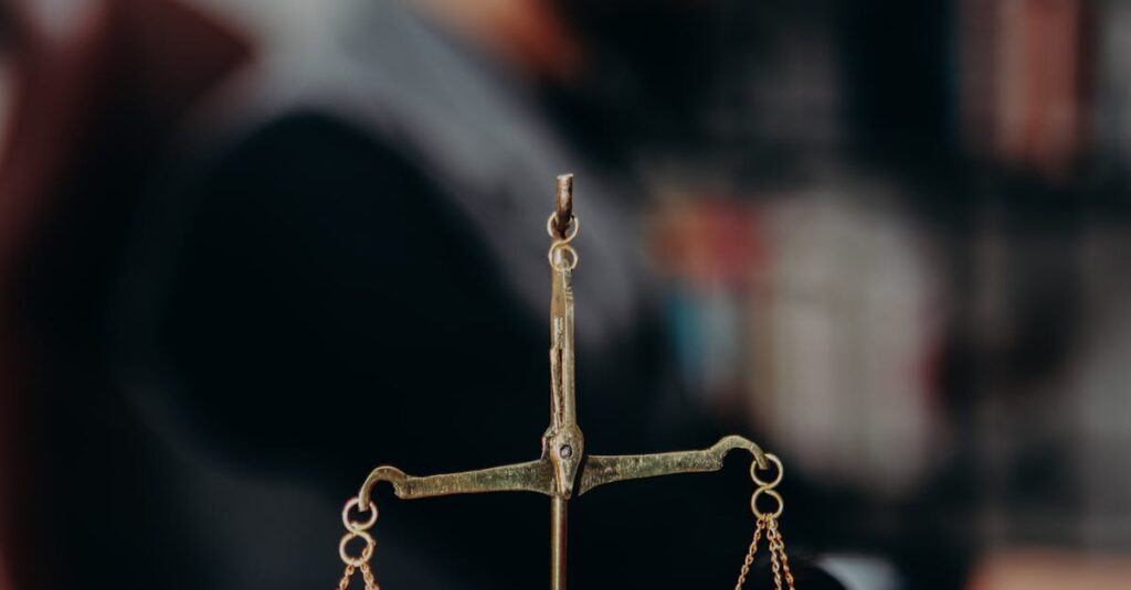 Close-up of justice scales and pipe on a lawyer's desk, emphasizing legal themes.