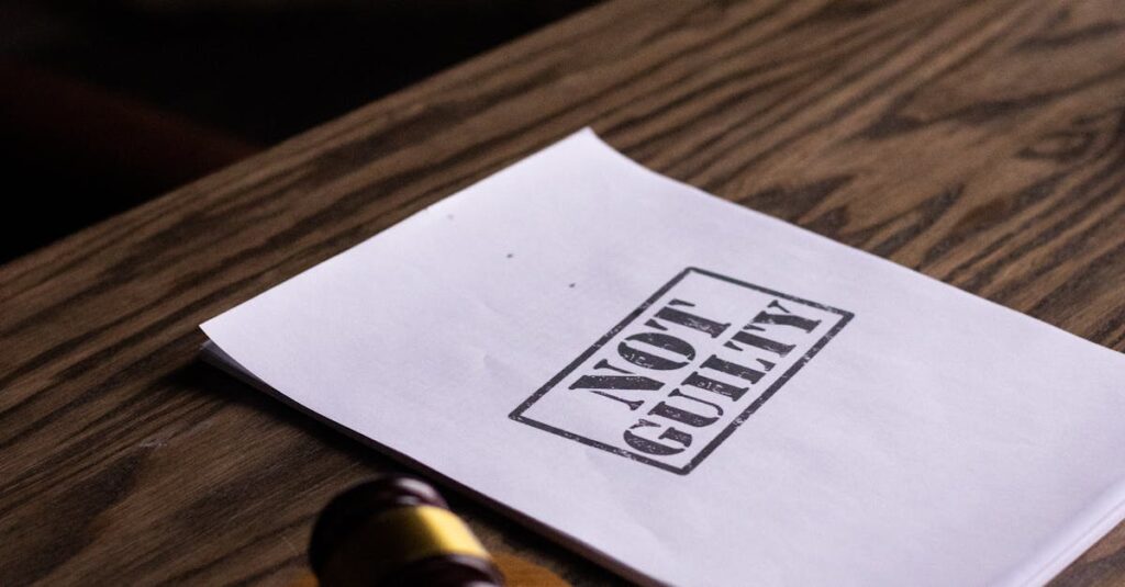 A legal gavel next to a 'Not Guilty' document on a wooden table, symbolizing justice.